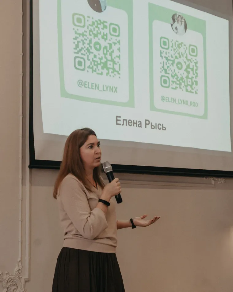 Психолог Елена Рысь выступает с микрофоном перед аудиторией