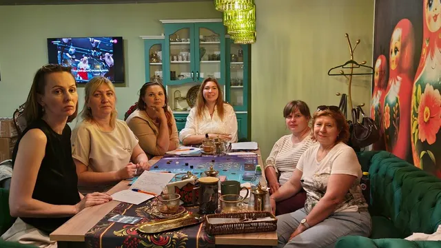 Участники встречи за столом с картами и игровым полем